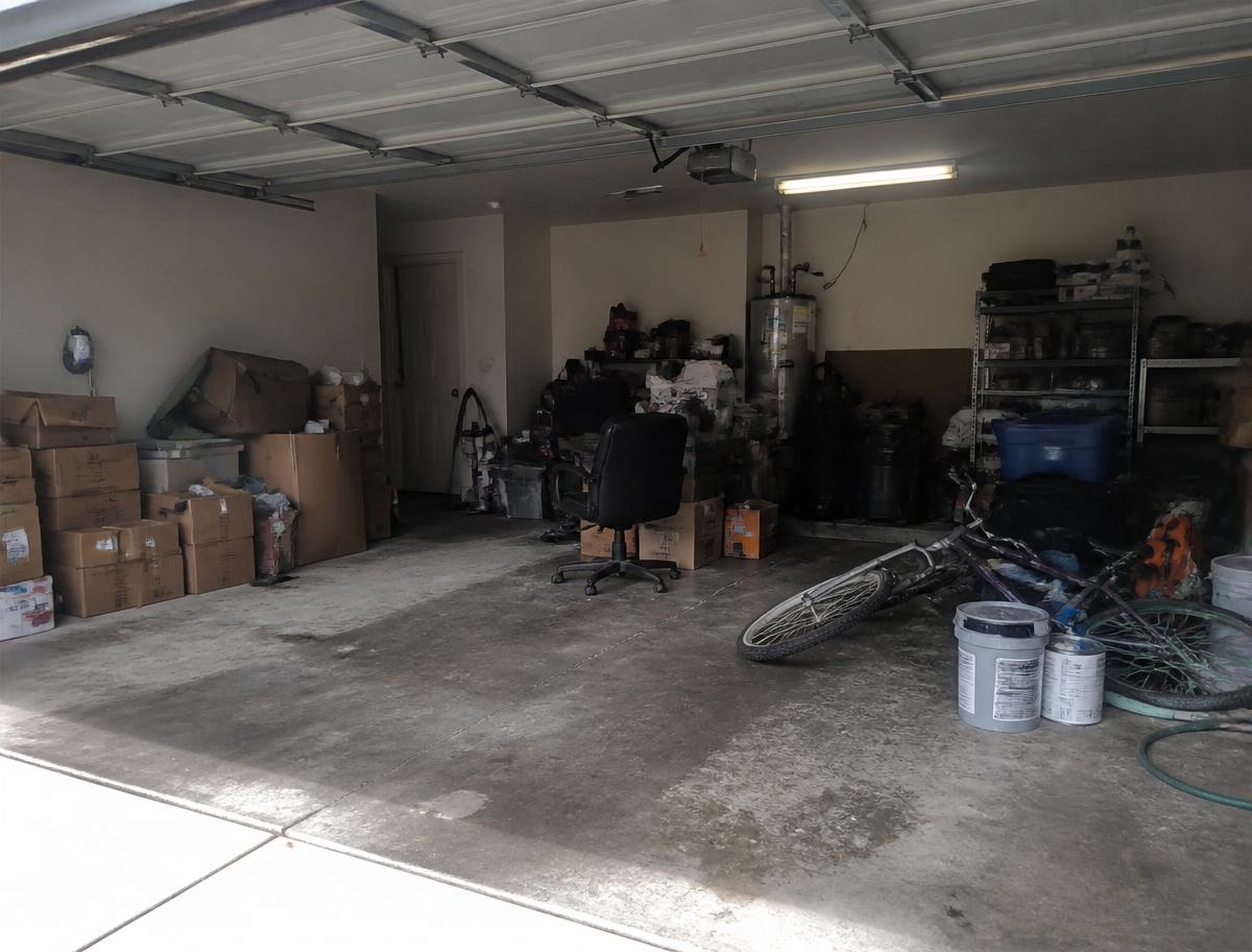 Cluttered two car garage in Las Vegas packed with boxes, tools and old furniture before a junk removal clean out